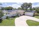 Charming single-story home featuring a circular driveway, well-manicured landscaping and solar panels at 411 Harbor View Ln, Largo, FL 33770
