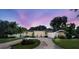 Beautiful home with a circular driveway, well-manicured lawn, and professionally landscaped grounds at 411 Harbor View Ln, Largo, FL 33770