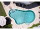 Aerial view of sparkling in-ground pool surrounded by brick patio and lush landscaping at 411 Harbor View Ln, Largo, FL 33770