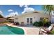 A refreshing pool is surrounded by a brick patio with seating and lush landscaping at 411 Harbor View Ln, Largo, FL 33770