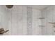 Close up of tiled shower with glass shelving and updated bronze shower head and faucet at 411 Harbor View Ln, Largo, FL 33770