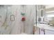 Modern shower with marble-style tile and glass doors, complemented by stylish fixtures and shelving at 411 Harbor View Ln, Largo, FL 33770