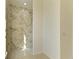 Walk-in tiled shower featuring decorative accent tiles and a shower head at 15154 Appleton Blvd, Port Charlotte, FL 33981