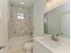 Modern bathroom with marble-like tiling in the shower and a white sink vanity at 15154 Appleton Blvd, Port Charlotte, FL 33981