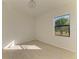 Bright bedroom offers neutral tones and ample natural light through its window at 15154 Appleton Blvd, Port Charlotte, FL 33981
