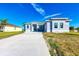 Modern house with a large driveway and manicured lawn on a sunny day at 15154 Appleton Blvd, Port Charlotte, FL 33981