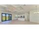 Bright living space with sliding glass doors and modern kitchen featuring stainless steel appliances and an island at 15154 Appleton Blvd, Port Charlotte, FL 33981