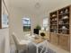 Stylish home office with a wooden desk, shelving, and a serene view from the window at 15154 Appleton Blvd, Port Charlotte, FL 33981