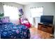 Cozy bedroom with floral bedding, a TV, and hardwood floors at 2109 58Th S St, Gulfport, FL 33707