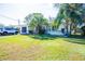 House exterior showcasing a light-colored facade, mature palm trees, and a spacious lawn at 2109 58Th S St, Gulfport, FL 33707