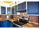 Kitchen with dark blue cabinets and brick backsplash at 2109 58Th S St, Gulfport, FL 33707