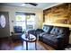 Living room features hardwood floors, a brown leather couch, and a rustic wood wall accent at 2109 58Th S St, Gulfport, FL 33707