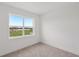 Bright bedroom featuring neutral carpet and a large window with views at 31907 Anchor Point Dr, Wesley Chapel, FL 33545