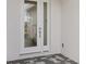 Close up of the front door, a full light door with sidelight, set in a stucco surround at 31907 Anchor Point Dr, Wesley Chapel, FL 33545