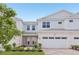 Charming two-story townhouse with a two-car garage, landscaped yard, and covered entryway at 31907 Anchor Point Dr, Wesley Chapel, FL 33545