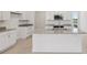 Close up of the kitchen island with granite countertop, stainless steel sink, and white cabinetry at 31907 Anchor Point Dr, Wesley Chapel, FL 33545