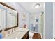 Bright bathroom with a walk-in shower, sink, and nice wallpaper at 7048 El Meyers St, Zephyrhills, FL 33541