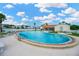 Large community pool surrounded by lounge chairs and palm trees at 7048 El Meyers St, Zephyrhills, FL 33541