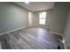 Well-lit bedroom showcasing wood-look floors and a window at 12106 Dagwood Way, Riverview, FL 33579