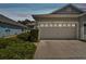 Two-car garage with driveway and landscaping at 6919 Surrey Hill Pl, Apollo Beach, FL 33572
