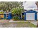 Bright blue house with a white garage door and landscaping at 3303 Russett Dr, Tampa, FL 33618