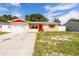 House exterior with a red door and attached garage at 8525 Fox Hollow Dr, Port Richey, FL 34668