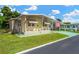 Mobile home with covered porch, landscaping, and American flag at 7048 El Meyers St, Zephyrhills, FL 33541