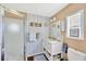 Bathroom with white vanity, shower, and decorative wallpaper at 7048 El Meyers St, Zephyrhills, FL 33541