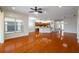 Open living room with hardwood floors, kitchen island and view into kitchen at 4943 Sandy Brook Cir, Wimauma, FL 33598