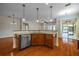 Kitchen island with sink and dishwasher, hardwood floors at 4943 Sandy Brook Cir, Wimauma, FL 33598