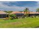 Backyard with screened lanai, lush landscaping, and golf course view at 4943 Sandy Brook Cir, Wimauma, FL 33598