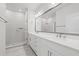 Bright bathroom boasts a double vanity, large mirror, and walk-in shower with tile surround at 2510 W Cleveland St # 2, Tampa, FL 33609