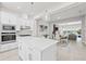 Bright kitchen boasts an island, white cabinets, stainless appliances, herringbone backsplash, and open floor plan at 2510 W Cleveland St # 2, Tampa, FL 33609