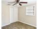 Neutral bedroom featuring wood-look floors, a ceiling fan, and a closet at 3245 Bigelow Dr Dr, Holiday, FL 34691