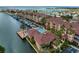 Aerial view of a waterfront community with boat docks, a pool, lush landscaping, and terracotta tile roofs at 5000 Culbreath Key Way # 4-306, Tampa, FL 33611