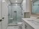 The remodeled bathroom features a tiled glass shower, white vanity and a modern mirror at 5000 Culbreath Key Way # 4-306, Tampa, FL 33611