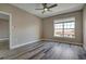 Bright, empty bedroom with wood-look floors, a ceiling fan, neutral paint, and a window for natural light at 5000 Culbreath Key Way # 4-306, Tampa, FL 33611