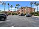 Condominium parking lot with multiple parked cars beneath palm trees and blue skies at 5000 Culbreath Key Way # 4-306, Tampa, FL 33611