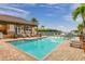 Inviting community pool area with comfortable lounge chairs, a pergola, and beautiful landscaping at 5000 Culbreath Key Way # 4-306, Tampa, FL 33611