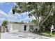 Front view of a freshly painted house with a blue door and a large tree at 3245 Bigelow Dr Dr, Holiday, FL 34691
