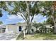 Charming single-story home with a white exterior and a well-manicured lawn at 3245 Bigelow Dr Dr, Holiday, FL 34691