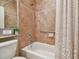 Well-lit bathroom featuring a tub and shower, tile surround, and neutral tones at 15626 Aurora Lake Cir, Wimauma, FL 33598