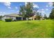 Spacious backyard with grassy lawn and mature trees at 15626 Aurora Lake Cir, Wimauma, FL 33598