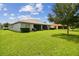 Expansive backyard featuring a large lawn and a home with screened patio at 15626 Aurora Lake Cir, Wimauma, FL 33598