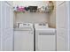 Laundry room with washer, dryer, and overhead shelving for storage at 15626 Aurora Lake Cir, Wimauma, FL 33598