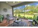 Spacious screened patio with outdoor seating and a view of the lush backyard at 15626 Aurora Lake Cir, Wimauma, FL 33598