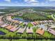 Aerial view of a community with houses, lake, and lush landscaping at 15626 Aurora Lake Cir, Wimauma, FL 33598
