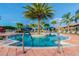 Inviting community pool with palm trees and lounge chairs at 15626 Aurora Lake Cir, Wimauma, FL 33598