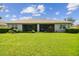 Large backyard with lush green grass and a screened patio at 15626 Aurora Lake Cir, Wimauma, FL 33598