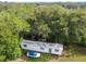 Aerial view of a mobile home on a wooded lot with a small boat at 5824 Portal Rd, New Port Richey, FL 34655